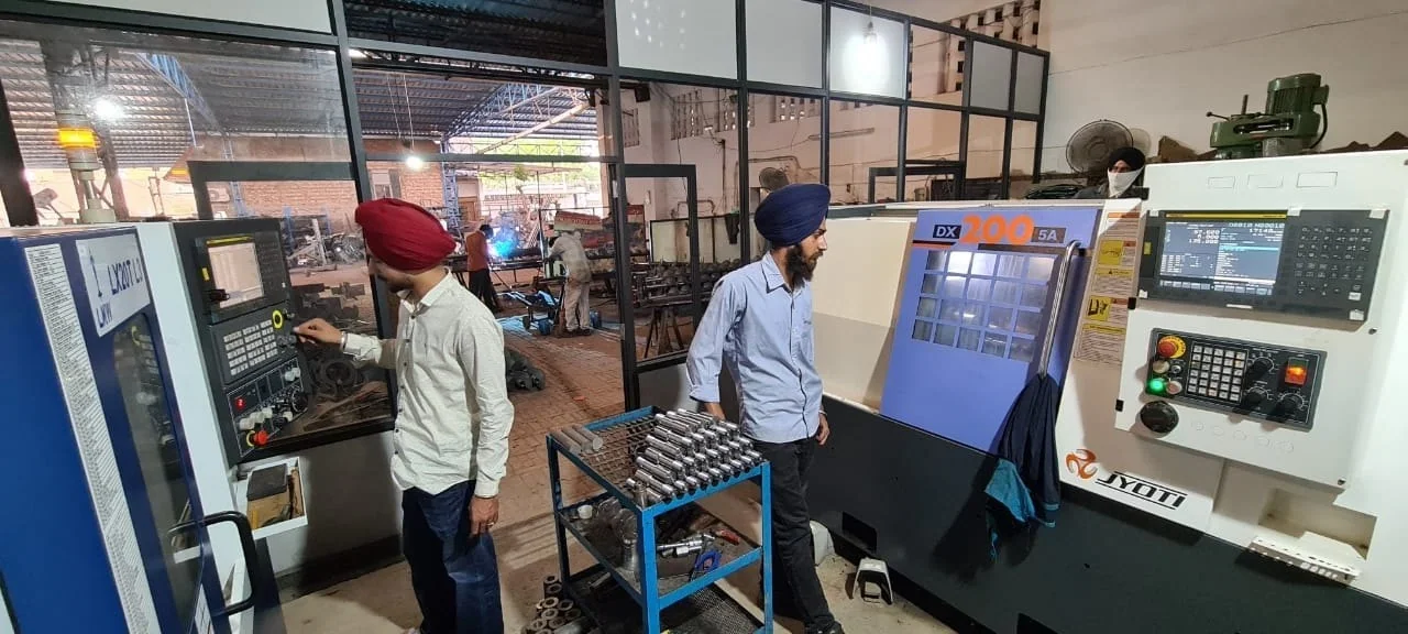 Jhandeana Industries team operating a CNC machine on the factory floor
