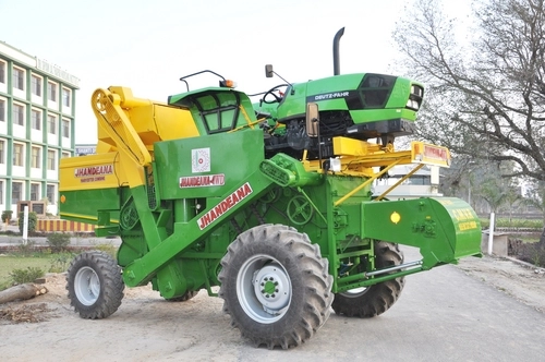 Tractor-driven harvester combine in green and yellow
